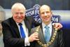 Past president Ian Faulds places the chain around the neck of new president Beaton Lindsay.