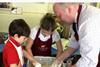 Hade Edge butcher Brindon Addy assists pupils at Holme Junior and Infant School as they mix the pastry for their own pork pies.