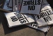 Strike placards that read 'no strike' are strewn on the ground.