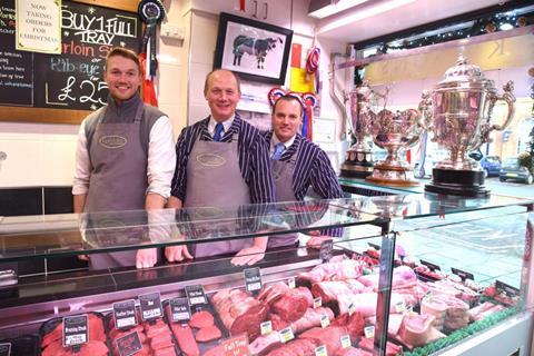 Oliver and Anthony Kitson with Martin Calvert in the Northallerton butchers shop with the three winter Fair trophies.