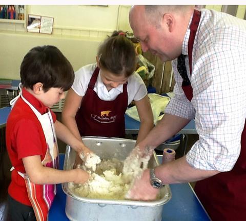 Hade Edge butcher Brindon Addy assists pupils at Holme Junior and Infant School as they mix the pastry for their own pork pies.